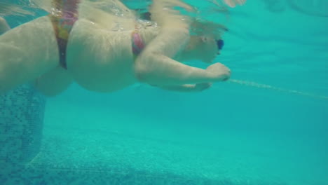 Vista-Submarina-De-Una-Mujer-Embarazada-Nadando-En-La-Piscina