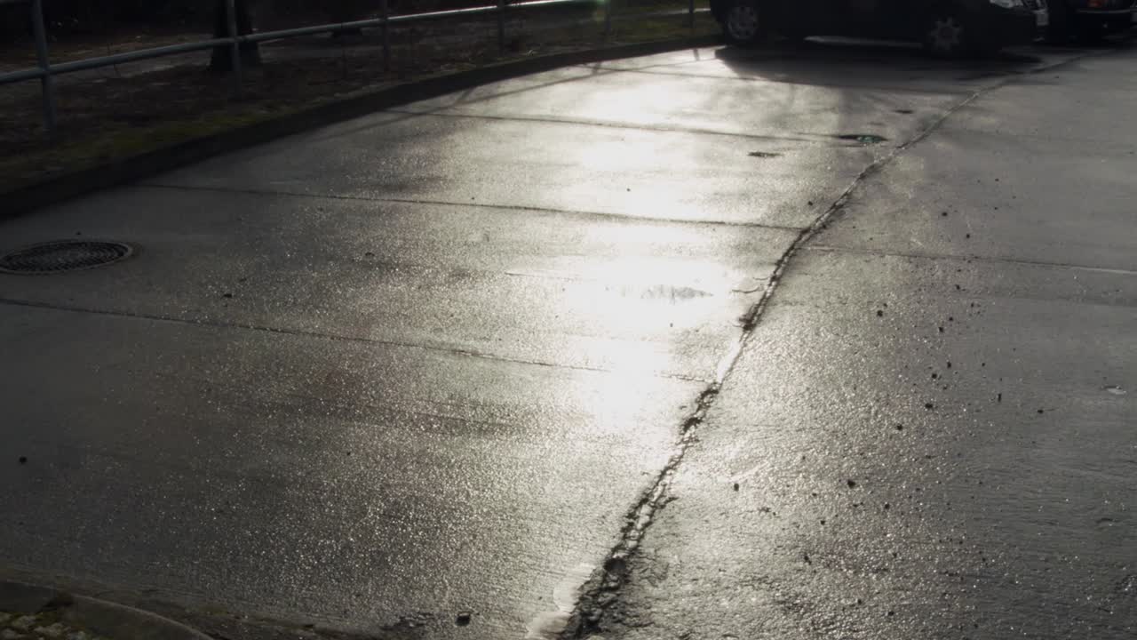 독일 베를린의 젖은 아스팔트에 밝게 빛나는 태양의 반사