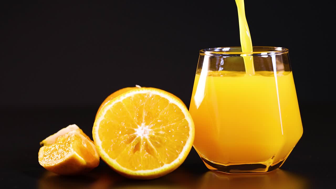 Orangensaft wird in ein Glas gegossen