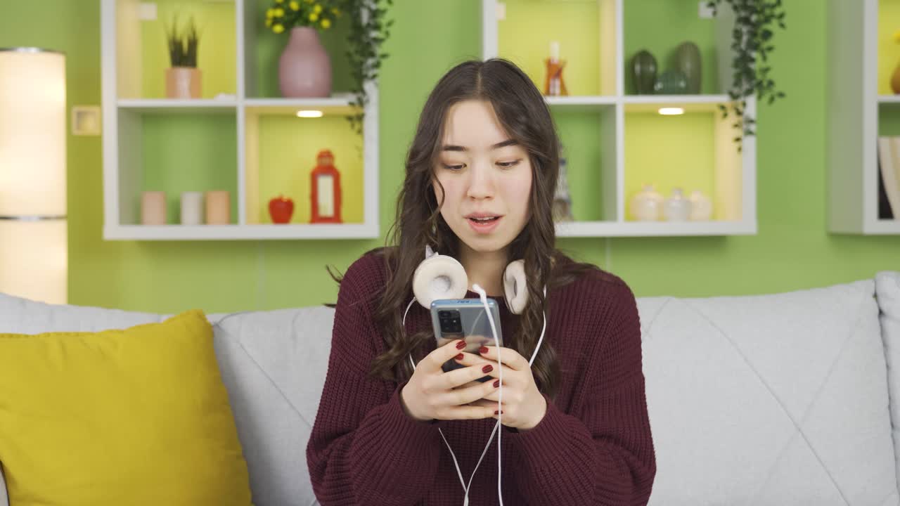 즐거운 아시아 젊은 여성이 음악을 듣고 있습니다.