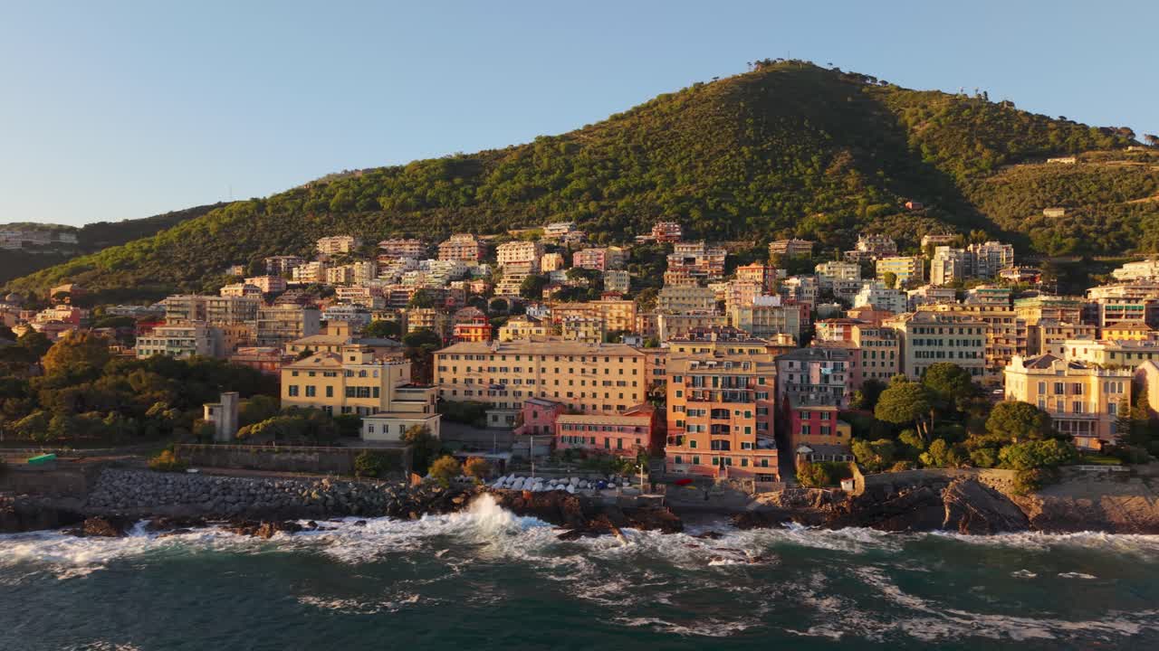 Mediterranean coastal town with colorful buildings, hillside, and sunset light