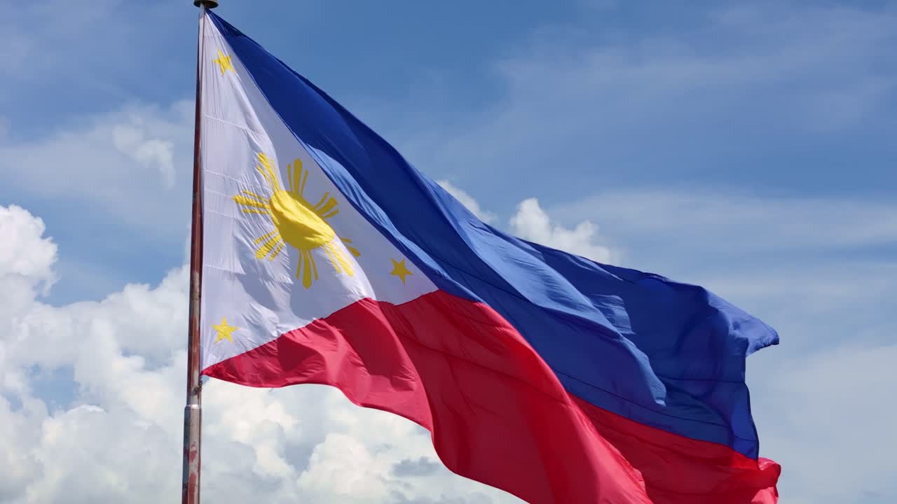 Philippine Flag on Flagpole Fluttering in Daytime Blue Sky