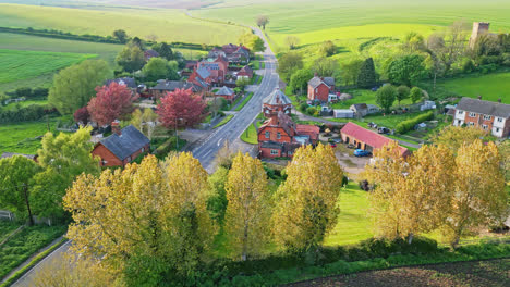 drone video presents burwell village, once a medieval market town, featuring countryside fields, old red brick houses, and the decommissioned saint michael parish church on the wold hills