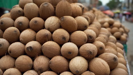 a large stack of coconuts at a market