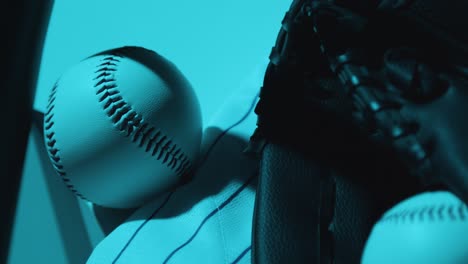 close up studio baseball still life with ball catchers mitt and team jersey with blue lighting 1