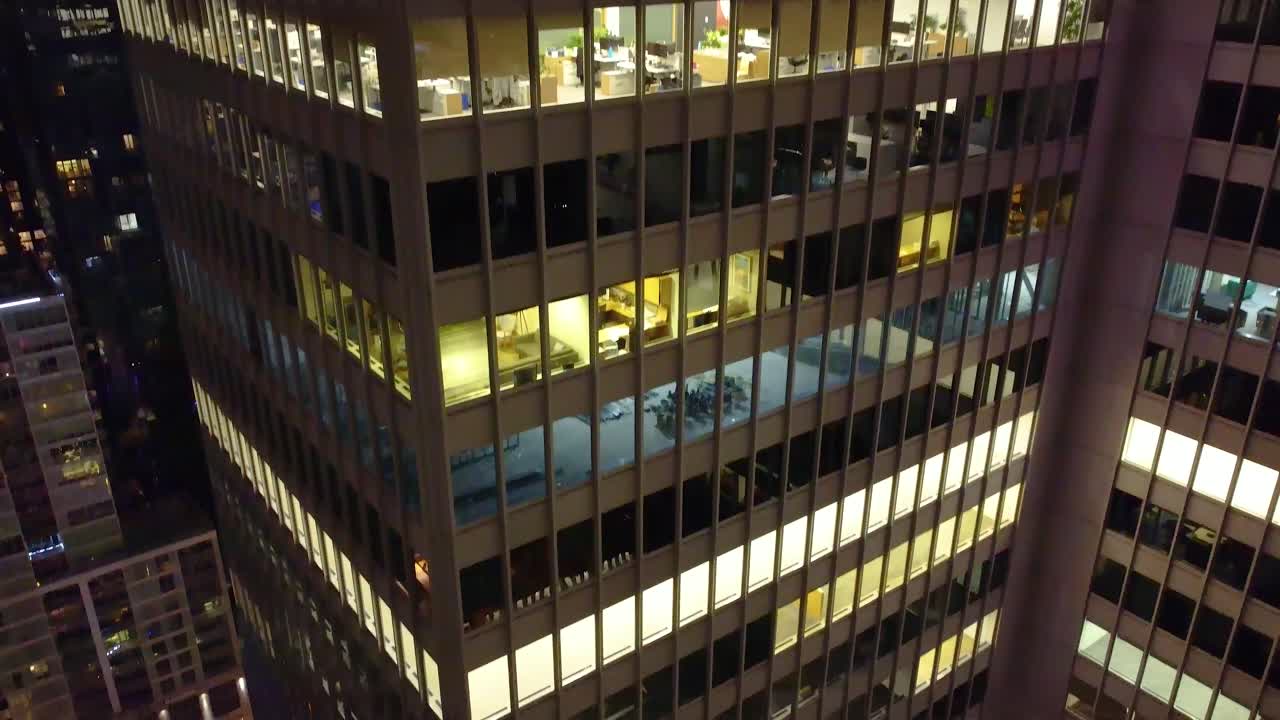edificio de oficinas en montreal por la noche con ventanas iluminadas y espacios de trabajo visibles