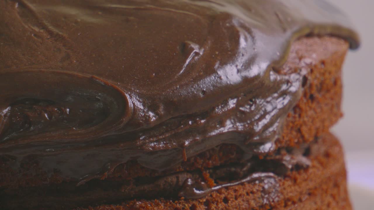 Indulgent Chocolate Sponge Cake with Creamy Icing with Close Up Details of Textures with Soft Natural Light. Slow Motion Food Baking Footage.
