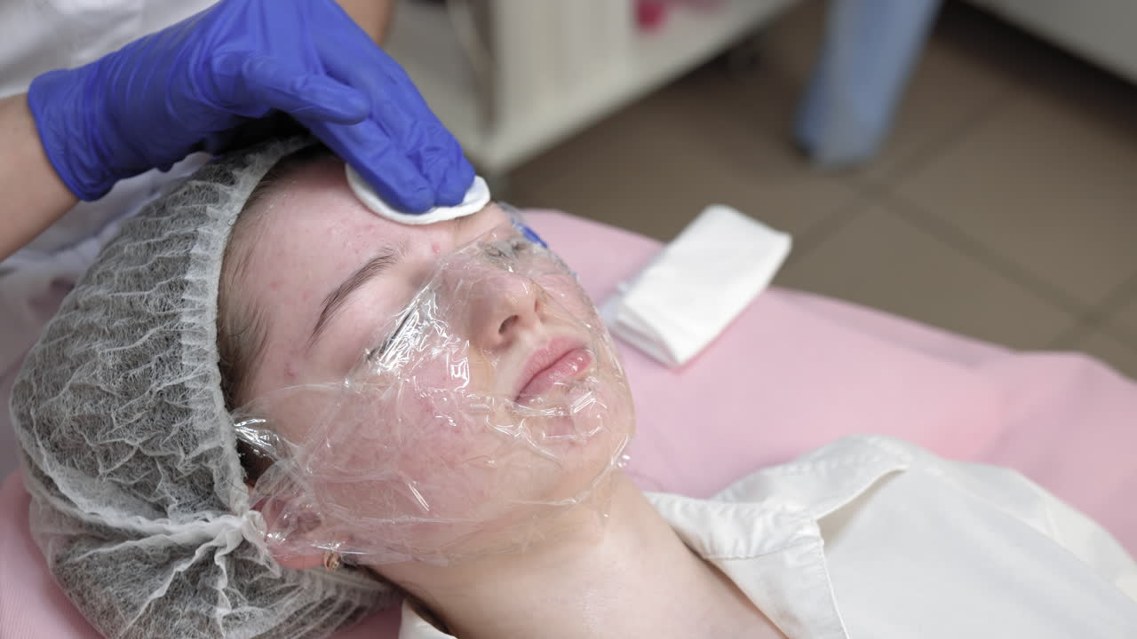 Teenage girl receiving facial treatment