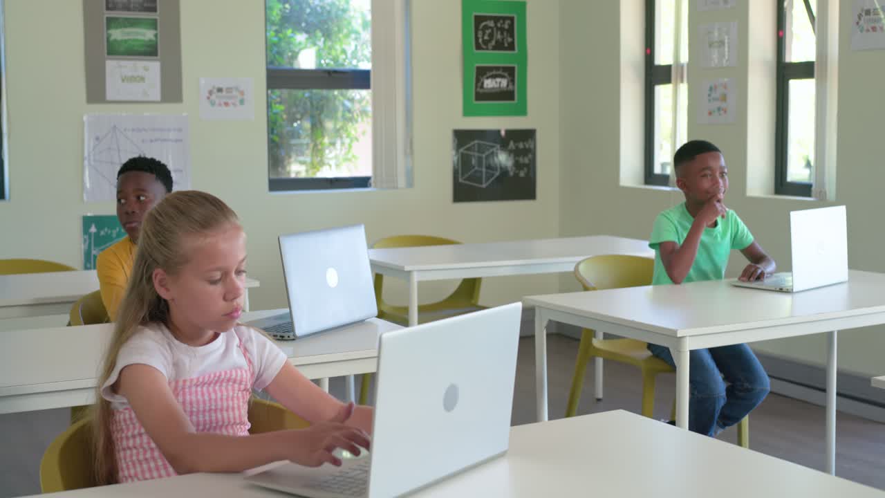African American teen in green tee in lesson sitting thinking typing on silver laptop, copy space