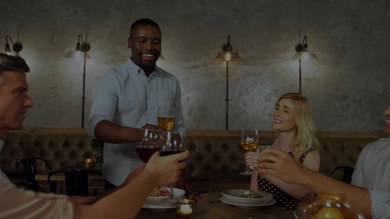 Standing man starting toast raising beer glass speaking toasting dining with bokeh showing glasses