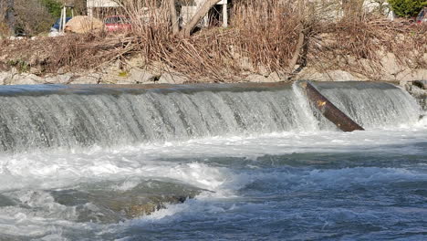 Slow-motion-footage-of-a-small-waterfall-of-ricer-Sora-in-Skofja-Loka,-Slovenia