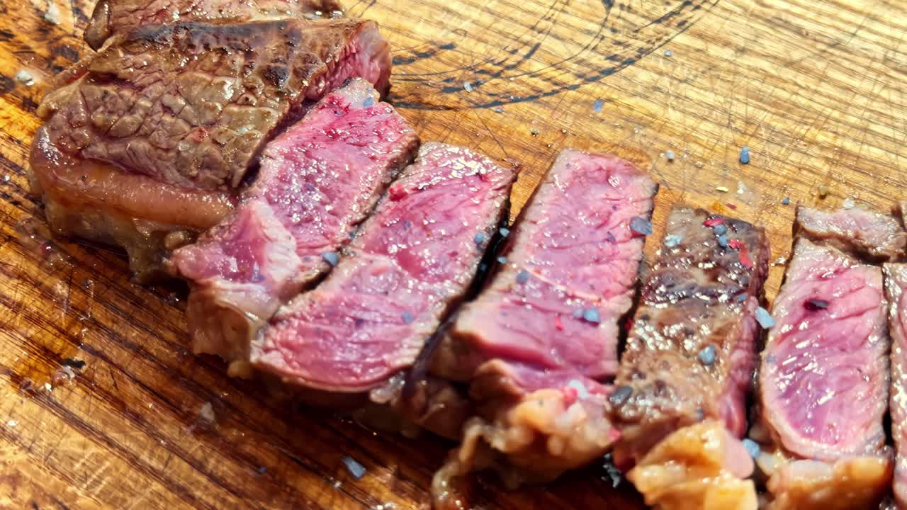 Fette di bistecca Wagyu cotta su un tagliere di legno. Primo piano