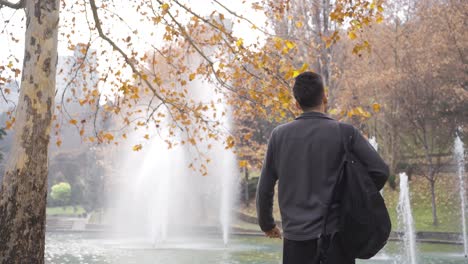 Young-male-student-is-dancing-in-the-park-and-is-happy.