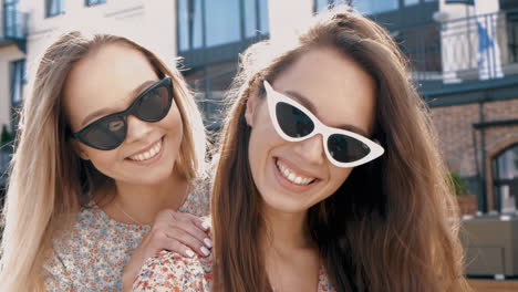 two happy women friends in sunglasses