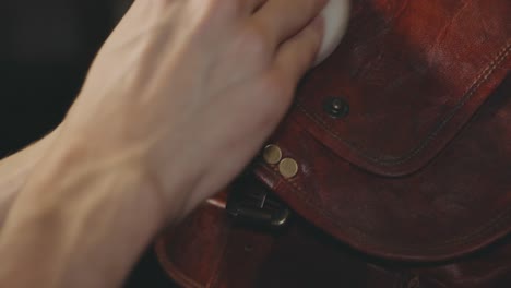 hand image polishing the flap of a vintage leather bag