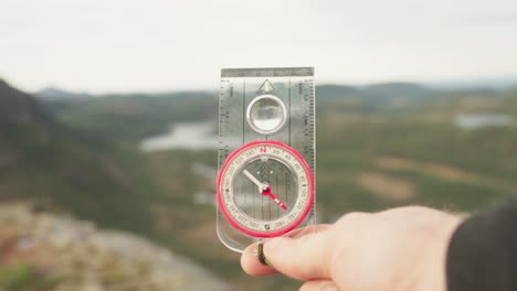 man holding a waterproof compass with liquid-filled protractor