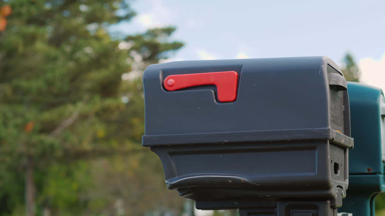 우체통에 우편물을 넣는 여자