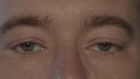 primer plano de un par de ojos masculinos azules que se abren y miran a la cámara