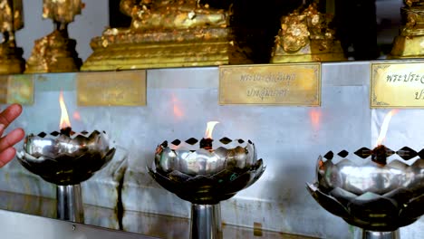 offering oil to temple lamps in bangkok