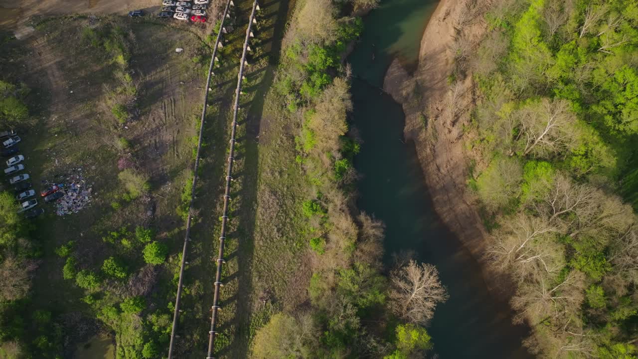 ojo de pájaro de viejas tuberías oxidadas a lo largo de un río salvaje y un depósito de chatarra olvidado