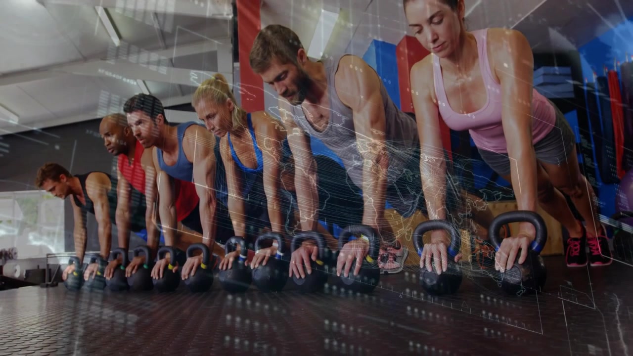 Deelnemers aan een fitnessles beginnen met kettlebell push-ups door hun ellebogen te buigen op de handvatten van de kettlebells.