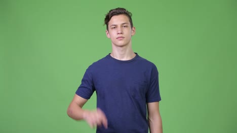 Young handsome teenage boy pointing up