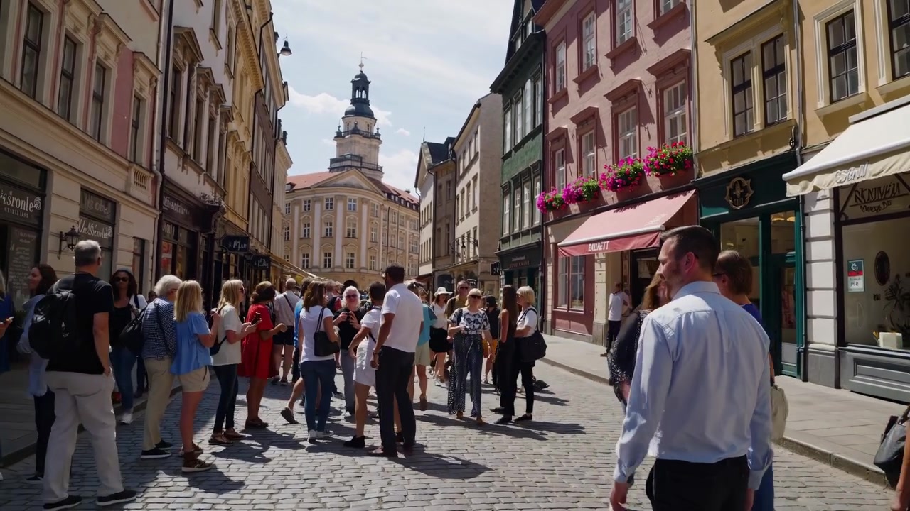 Turister lytter til en guide og går i en historisk bygata