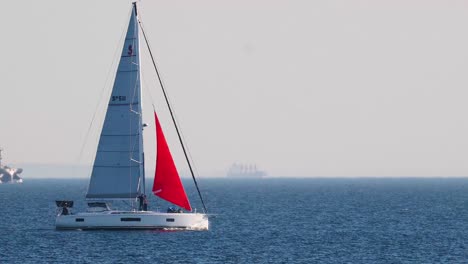 a sailboat with red sails on the ocean