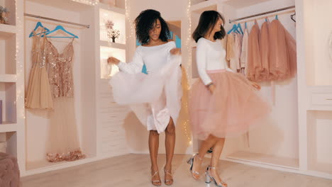 two women dancing in a fashionable walk-in closet