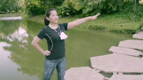 asian woman exercise in park outdoor with new normal in covid-19 situation