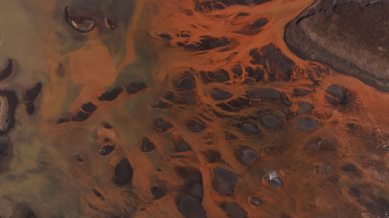 Aerial - braided Thjorsa River with orange and black textures in Iceland