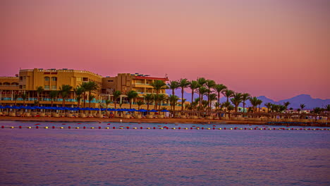 Luxurious-Vacation-Destination-With-Beachfront-Resort-Line-With-Palm-Trees-During-Sunset