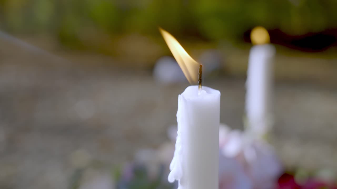 vela blanca ardiendo en la parte superior de la nueva tumba, vista de cámara lenta de cerca