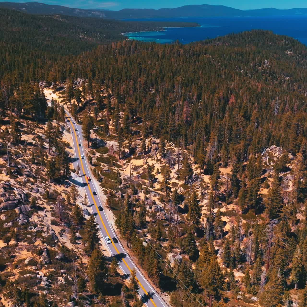 Admirable panorama of rocky land covered with pine trees. Amazing azure of Lake Tahoe on sunny hot day