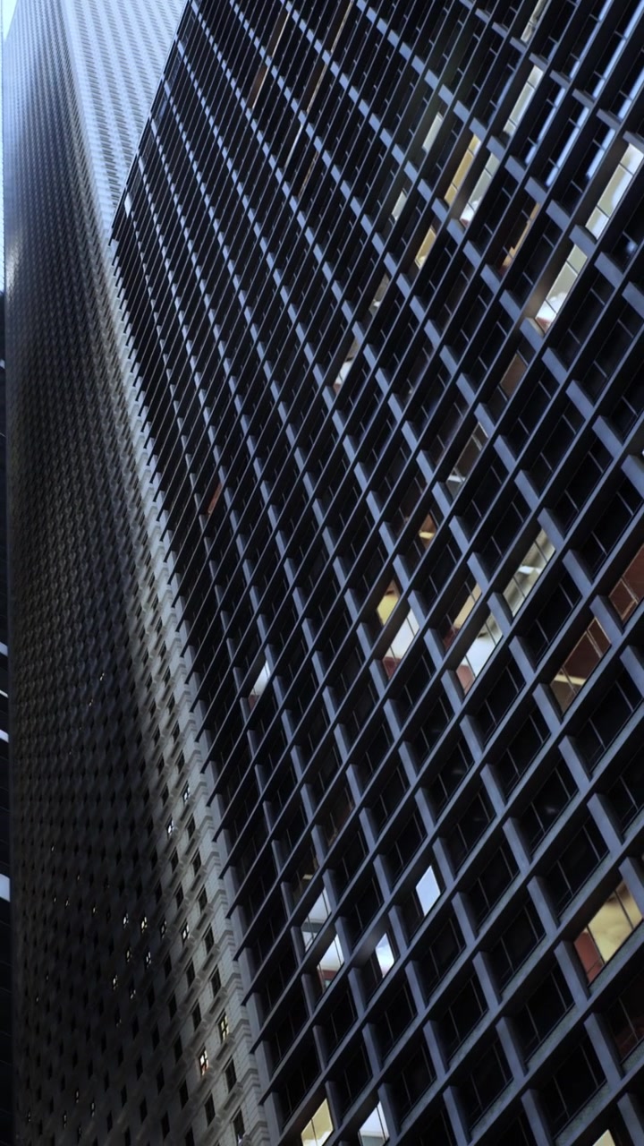 Tall building reaches towards blue sky in urban setting during daylight