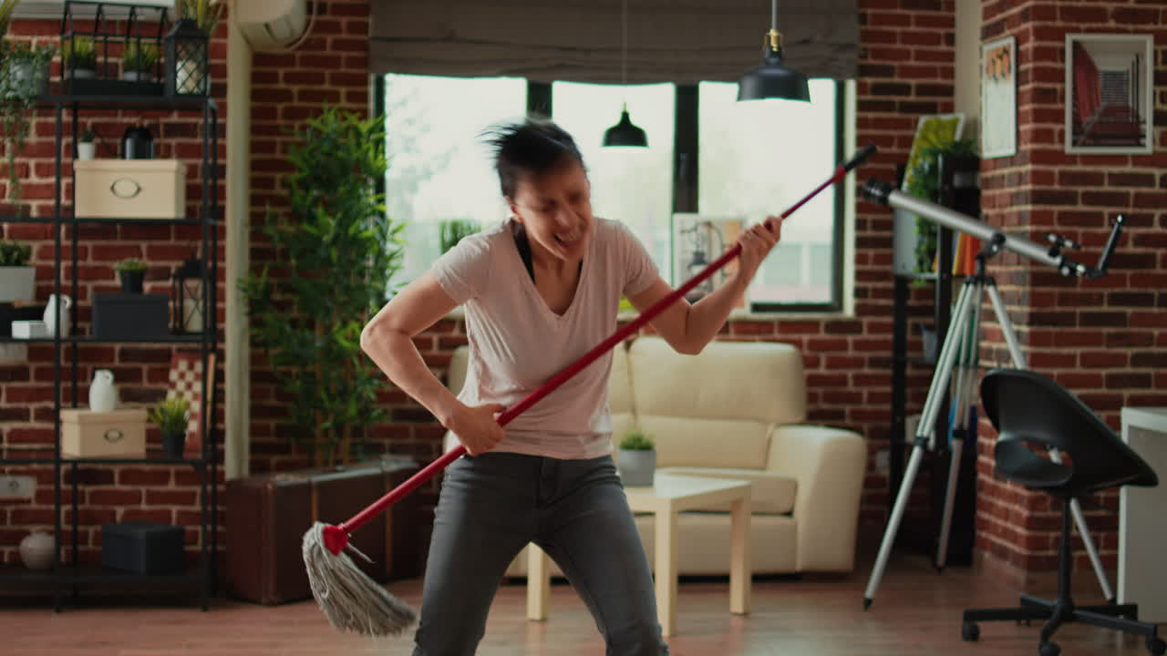 Smiling person cleaning living room floors with mop