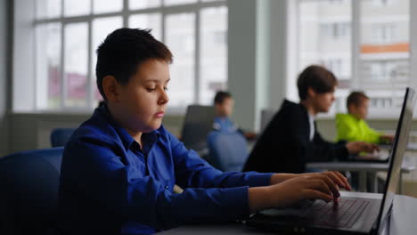 Boy using laptop in class
