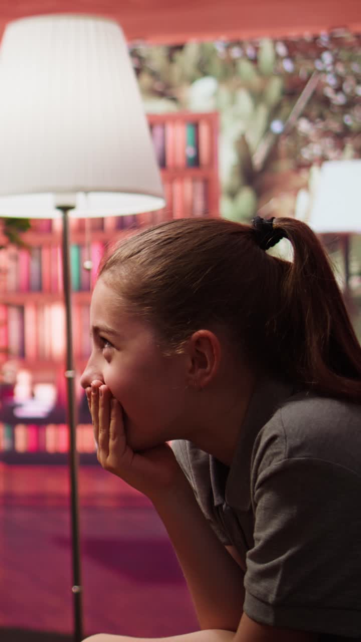 Giovane ragazza che reagisce con sorpresa e divertimento, coprendosi la bocca.