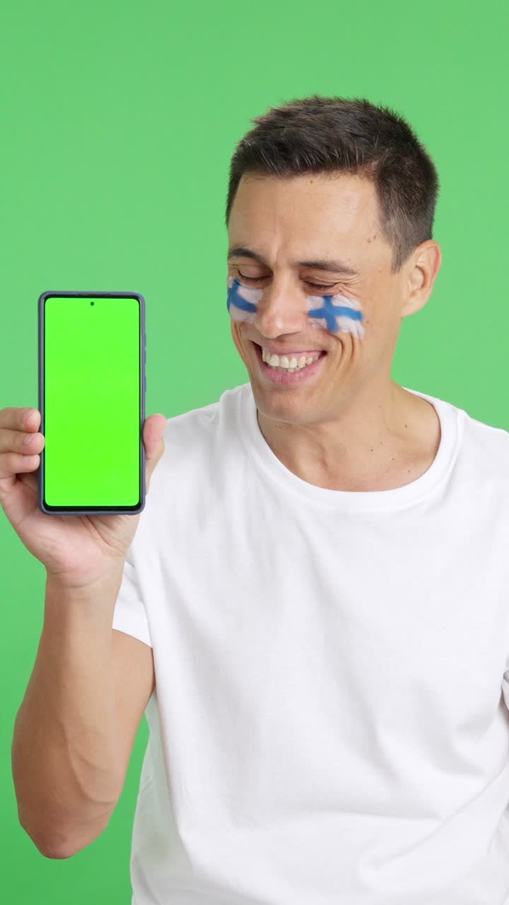 Finnish supporter looking at his mobile smiling and showing it
