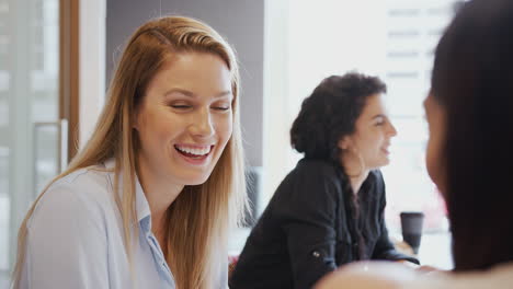 Junge-Geschäftsfrauen-Treffen-Sich-Am-Tisch-Und-Diskutieren-In-Einem-Modernen-Arbeitsbereich