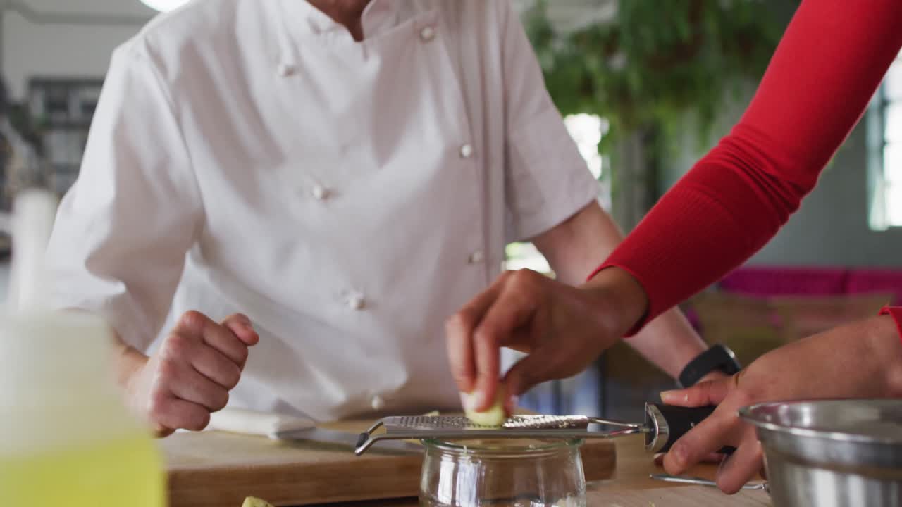 cocinera caucásica que enseña a un grupo diverso