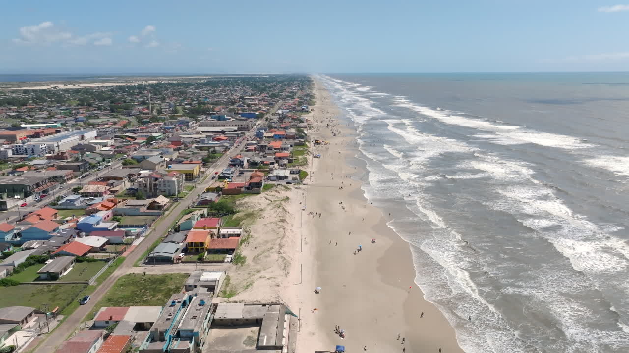 Dronen eteenpäin lento Balneario Pinhalin rannikkoa ja kaupunkia pitkin Brasiliassa. Kuvattu D-Log-muodossa 10-bittisellä värillä Hasselblad-kennoa käyttäen.