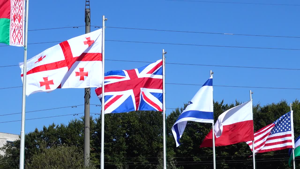 Flags of Belarus, Georgia, Great Britain, Israel, Poland, USA, Uzbekistan and Ukraine on flagpoles