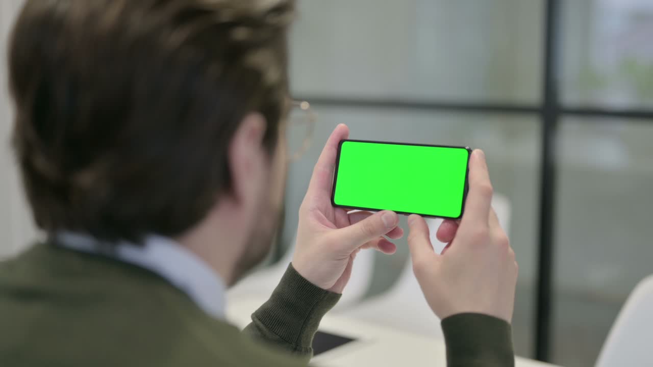 크로마 화면 을 가진 스마트폰 을 보고 있는 사업가
