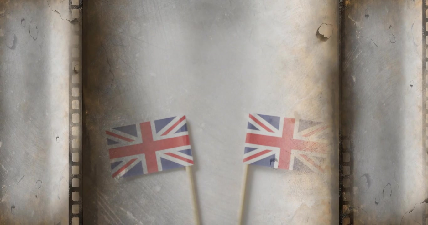 Con due bandiere Union Jack su uno sfondo in studio con perforazioni di pellicola, con bokeh fluttuante e polvere.