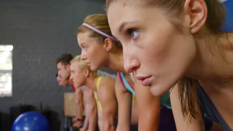 grupo de personas realizando flexiones con kettlebell