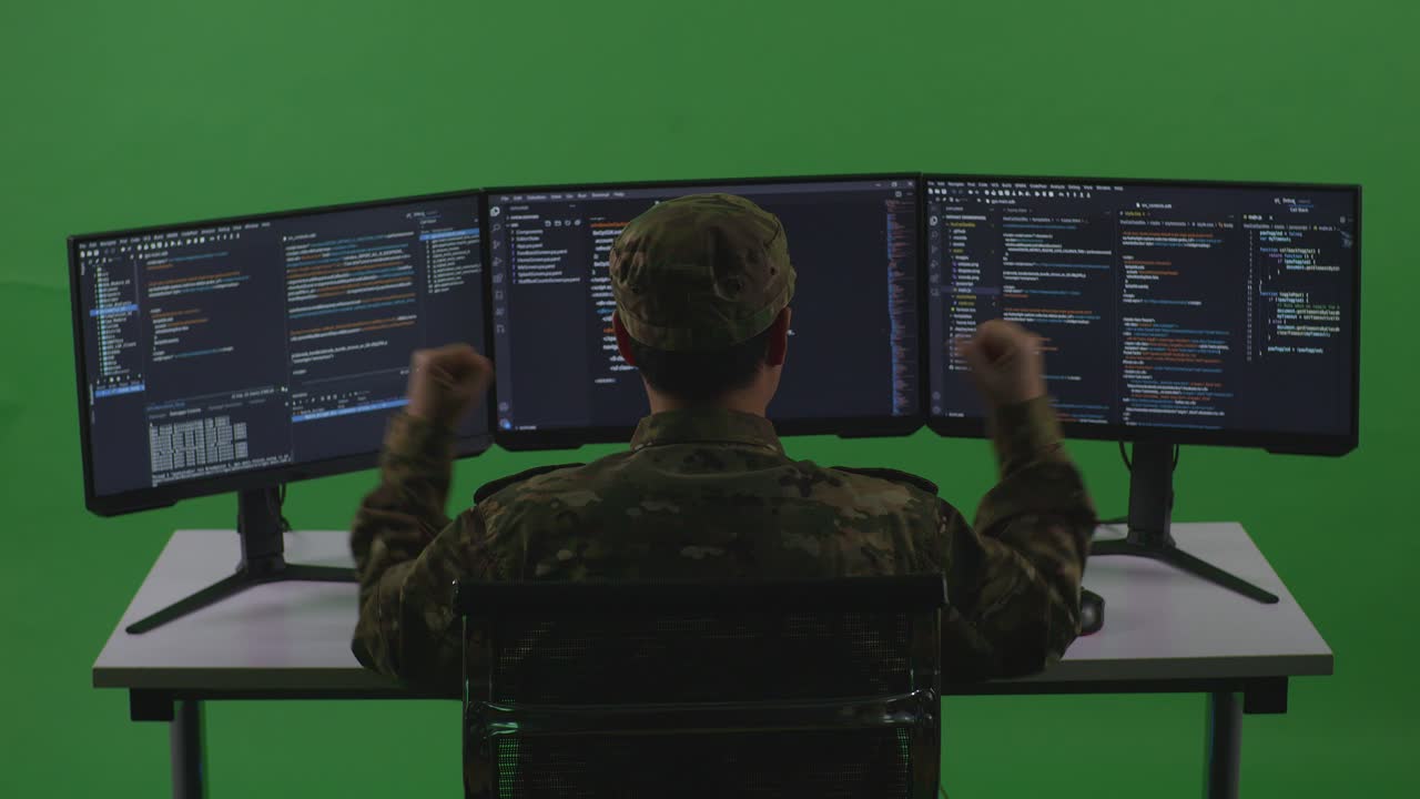 Back View Of Happy Asian Man Soldier Developer Celebrating While Write Code With Multiple Computer Screens In Green Screen Studio