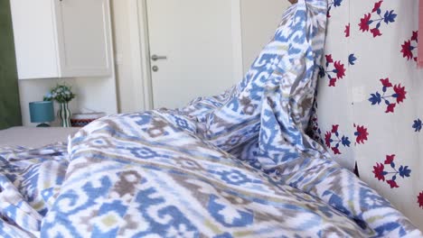 close-up of a white and blue patterned bedspread in a bedroom