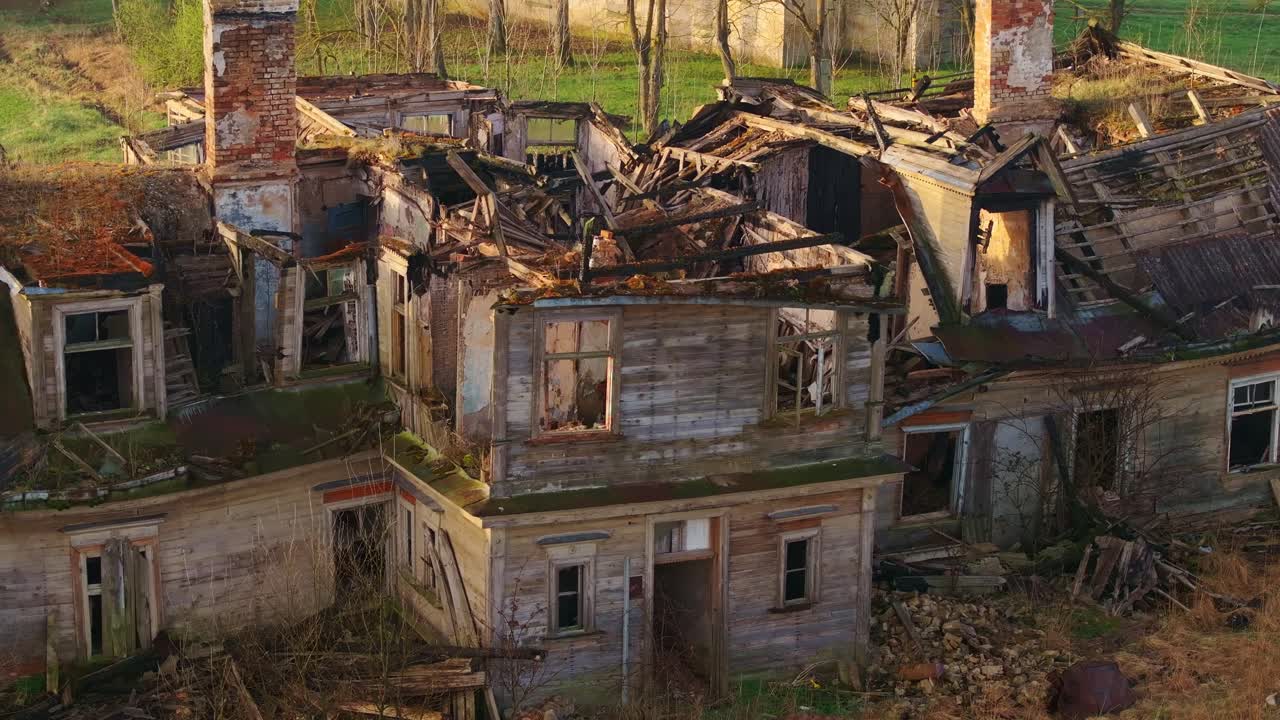 Filmato a distanza ravvicinata di un drone su una casa abbandonata in legno bruciata nella luce soffusa del mattino