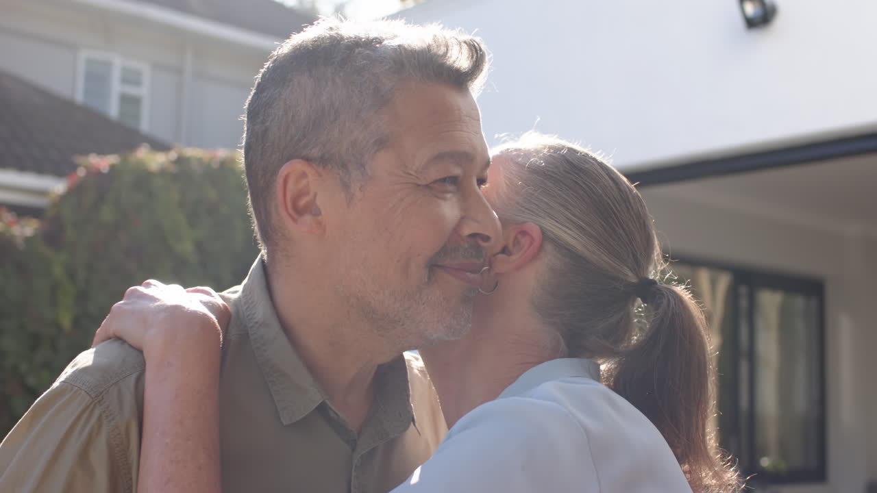 Hugging and smiling, senior friends enjoying warm moment outdoors together